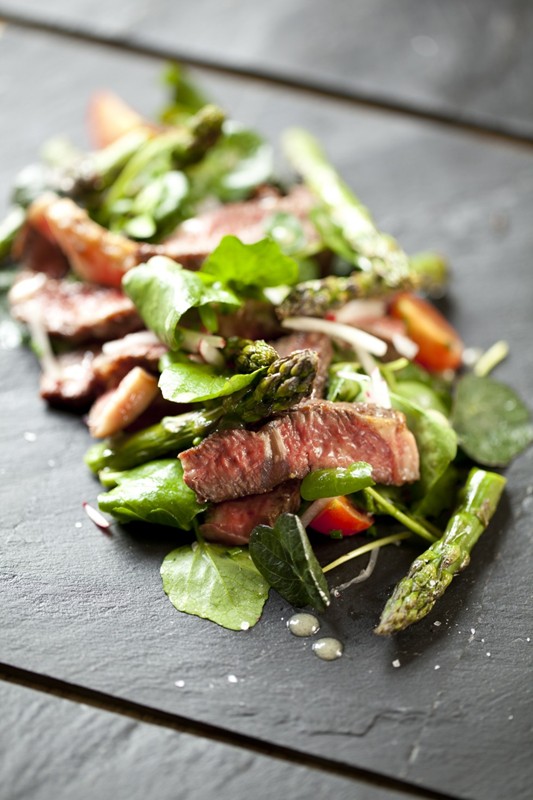 Beef and asparagus salad with honey dressing, radishes and cherry tomatoes